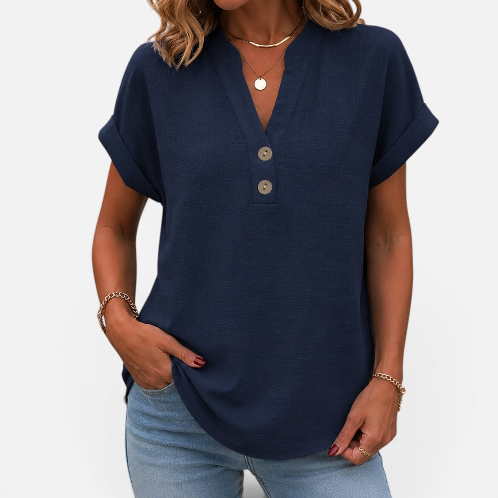 Woman wearing a navy short-sleeve blouse with a V-notch button placket, front view