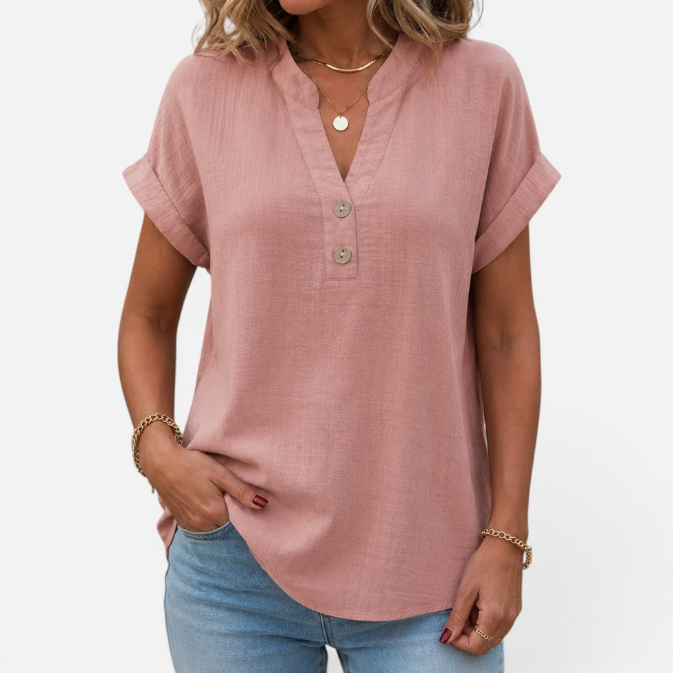 Woman wearing a dusty pink short-sleeve blouse with a V-notch button placket, front view
