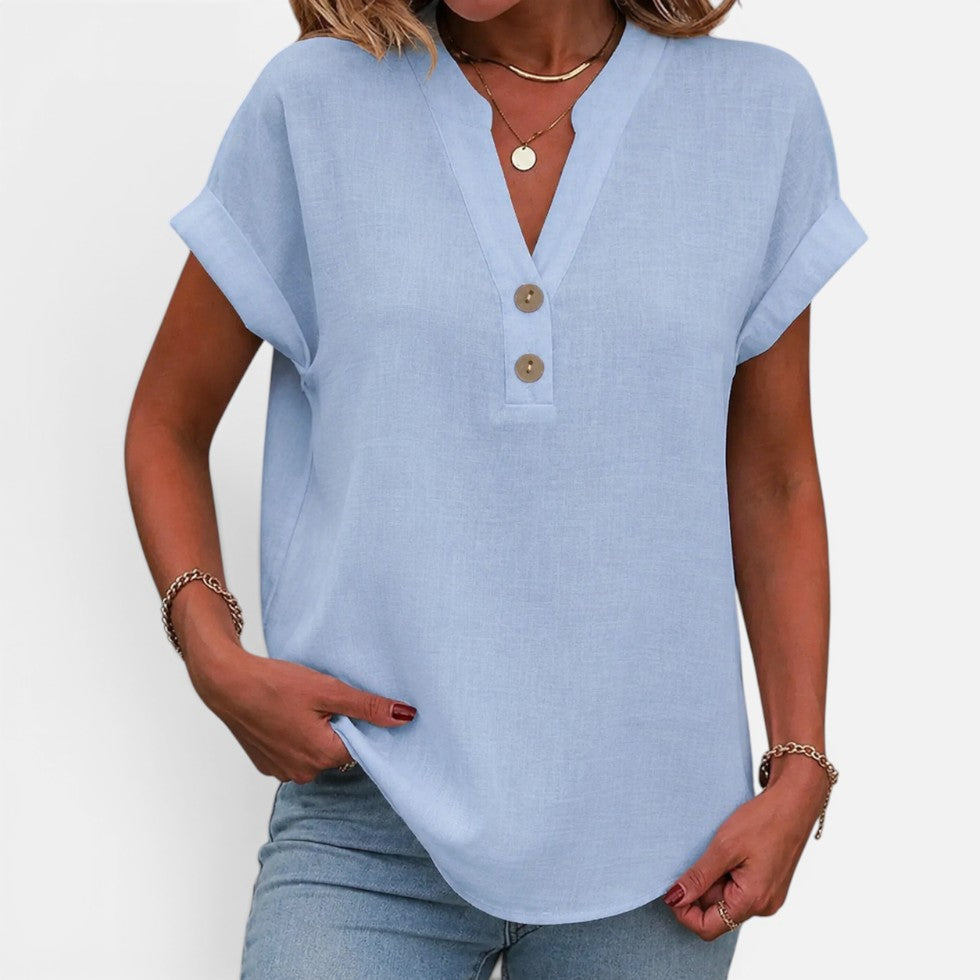 Woman wearing a light blue short-sleeve blouse with a V-notch button placket, front view