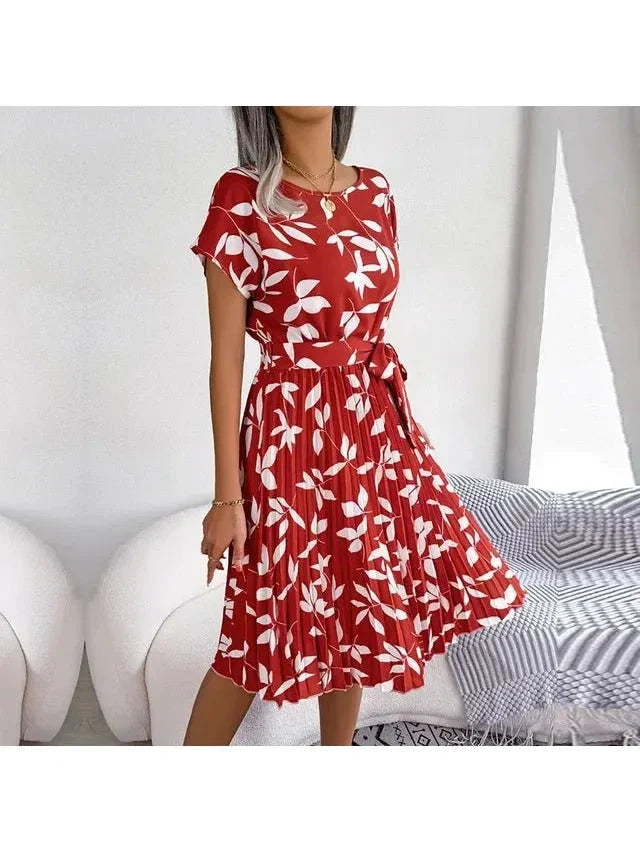Woman wearing a deep-red white-leaf-print midi dress with pleated skirt and waist tie