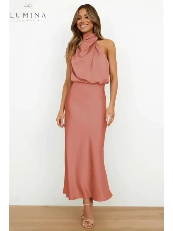 Woman wearing a pink draped halter-neck midi dress, front view