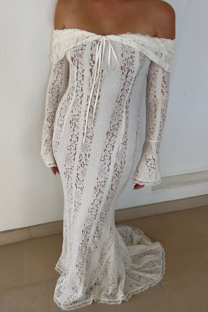 Close-up rear view of a white off-shoulder lace maxi dress with lace-up back and fluted sleeves