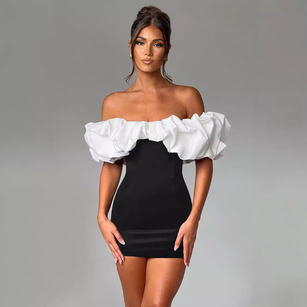 Black and white Aurora off-shoulder mini dress, featuring a stylish, fitted silhouette and elegant neckline.
