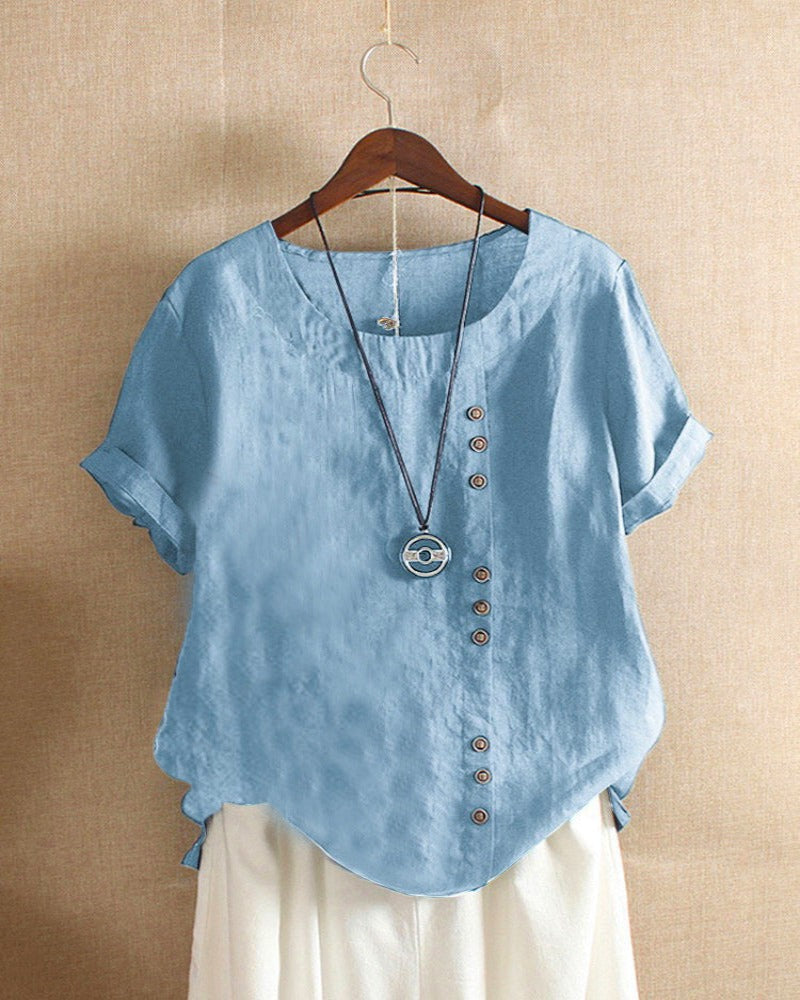 Light beige Beatrice summer blouse featuring relaxed fit and button details, displayed on a hanger.