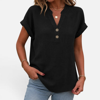 Woman wearing a black short-sleeve blouse with a V-notch button placket, front view