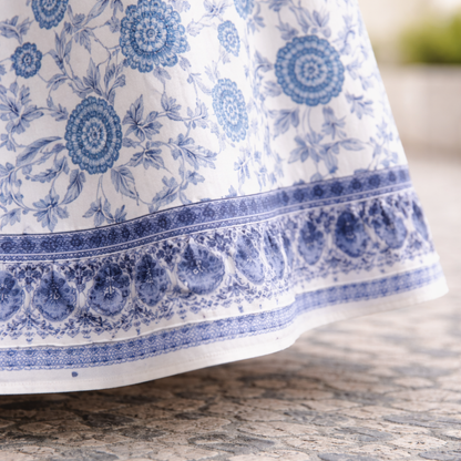 Close-up of blue floral print and patterned border on the white maxi dress