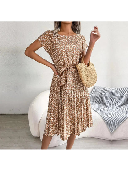 Woman wearing a light-brown floral midi dress with pleated skirt and waist tie