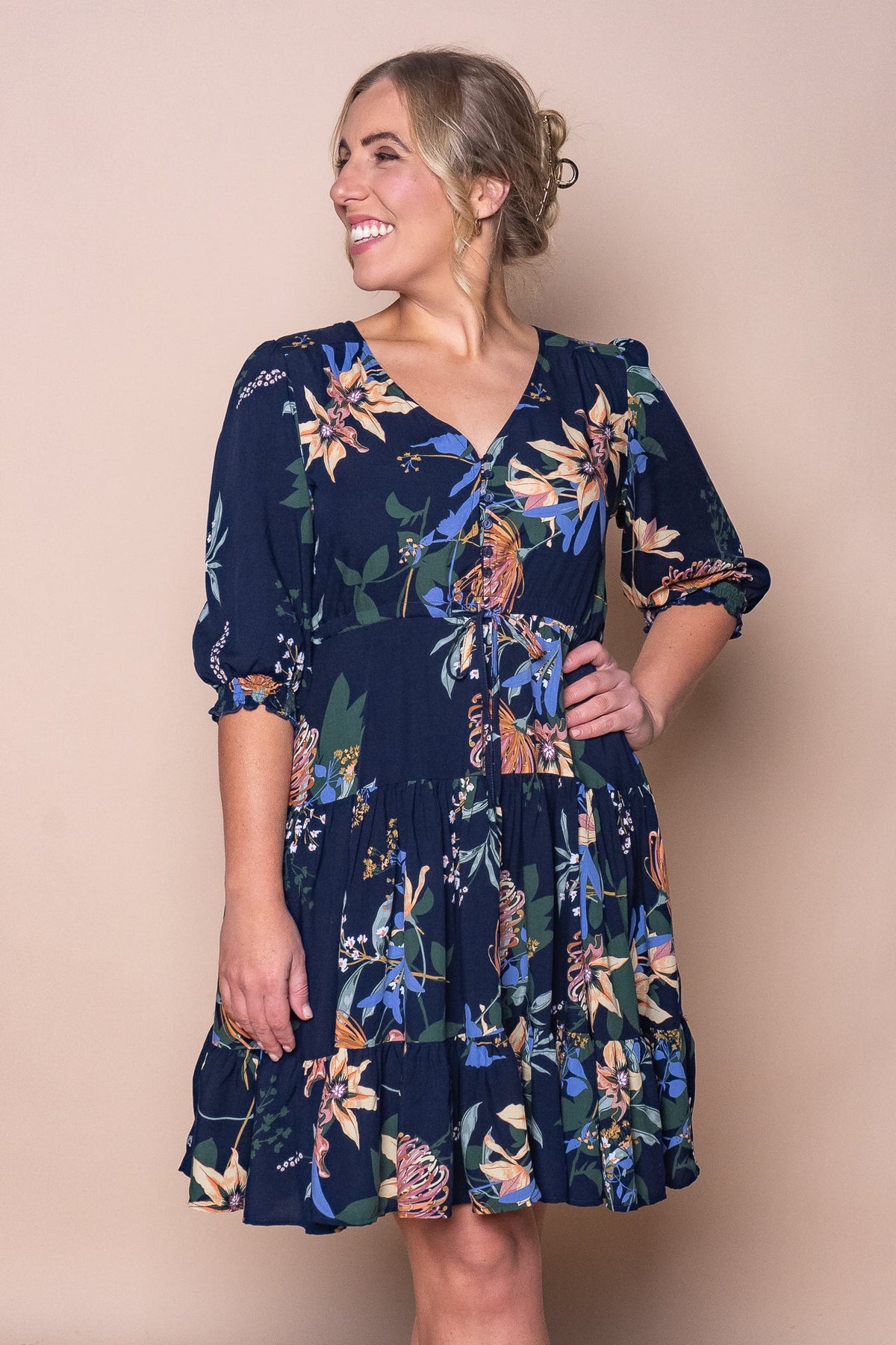 Woman wearing a navy floral knee-length dress with three-quarter sleeves