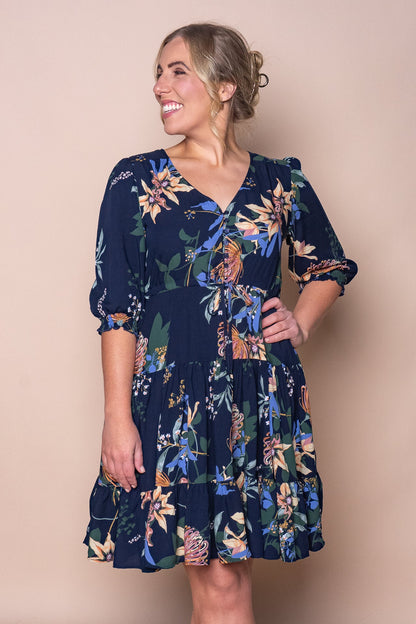 Woman wearing a navy floral knee-length dress with three-quarter sleeves