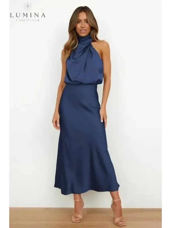 Woman wearing a dark-blue draped halter-neck midi dress, front view