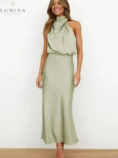 Woman wearing a light-green draped halter-neck midi dress, front view