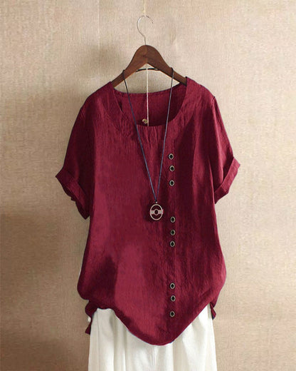 Light beige Beatrice casual blouse with relaxed fit and button details, styled with rolled sleeves.