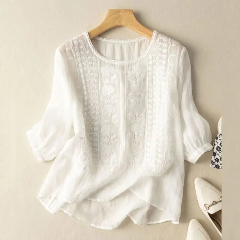 Front view of a white blouse with raised floral motifs on the front panels