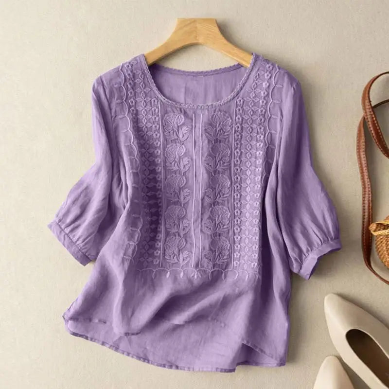 Front view of a purple blouse with raised floral motifs on the front panels