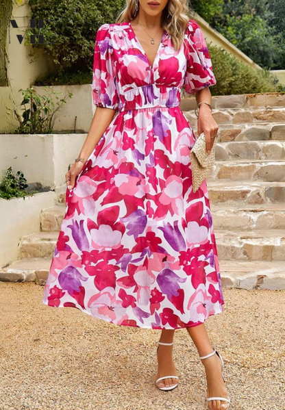 Woman wearing a pink-and-white floral V-neck midi dress, front view