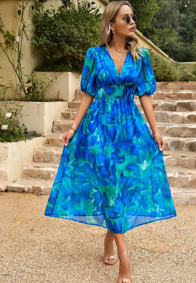 Woman wearing a blue-and-teal abstract floral V-neck midi dress, front view